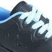 A close-up of a black Genuine Grip women's composite toe athletic shoe with blue accents.