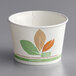 A white paper cup with green and brown leaves.