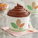A Bare by Solo paper food cup filled with chocolate ice cream on a counter with a wooden spoon.