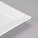 A close-up of a white rectangular porcelain platter with a rippled design.