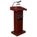 An Oklahoma Sound mahogany podium with a microphone and speakers.