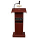 A mahogany podium with a microphone and speaker.