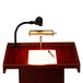 An Oklahoma Sound mahogany podium with a microphone and pen on top.