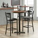 A Lancaster Table & Seating butcher block table with three bar stools in a restaurant.