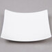 A white Arcoroc square porcelain plate with a small square cut out.