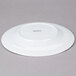 An Arcoroc white porcelain dinner plate with a small rim.