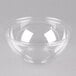 A Sabert clear plastic bowl on a white surface.