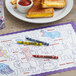 A plate of grilled cheese sandwiches and crayons on a table.
