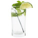 A Libbey Collins glass filled with clear liquid, ice, and lime wedges.