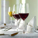 A table set with Stolzle wine glasses and silverware.