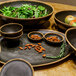 A group of GET brown melamine bowls with food on a table.