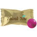 A close-up of a "Thank You" chocolate buttermint in a pink foil wrapper.