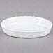 A CAC white oval deep dish platter on a gray surface.