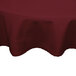A burgundy Intedge round tablecloth on a table.