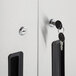 The hinged doors on a Regency stainless steel wall cabinet with a key in the lock.