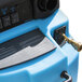A close up of a blue Mytee Speedster water tank with a hose attached.