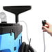 A person using the Mytee All-in-One Corded Detail Machine to vacuum a carpet.
