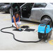 A woman using the Mytee Spyder Automotive Heated Extractor to clean a car's upholstery.