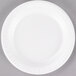 A Dart white foam plate with a white rim on a gray surface.