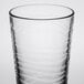 A close up of a Libbey wavy cooler glass with a curved edge.
