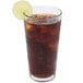 A Libbey wavy cooler glass of cola with ice and a slice of lime.