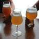 A group of Luigi Bormioli Birrateque wheat beer glasses on a table.
