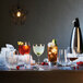 A table with Luigi Bormioli Spanish Gin and Tonic glasses filled with different colored drinks.