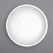 A white International Tableware porcelain bowl with a white rim on a gray surface.