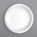 A close-up of an International Tableware Bristol white porcelain serving bowl with a white rim.