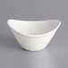 An International Tableware Dover white porcelain bowl with a curved rim on a gray surface.