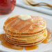 A stack of Golden Dipt Pancakes with butter and syrup on top.