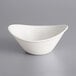 An International Tableware Dover porcelain bowl with a curved rim on a gray surface.