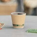 A EcoChoice double wall Kraft paper hot cup of coffee on a table.