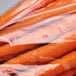 A close-up of carrots in clear plastic produce bags.
