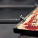 A GI Metal pan gripper lifting a pizza in a pan.