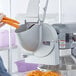 A person using a mixer shredder attachment to shred carrots.