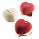Three heart-shaped desserts with white and red decoration on a white background.