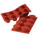 A red Silikomart silicone baking mold with 8 big oval cavities.