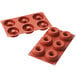 A red Silikomart silicone baking mold with donut-shaped cavities.