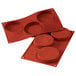 A red Silikomart silicone baking mold with four compartments.