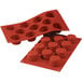 A red Silikomart silicone baking mold with 11 small cavities.
