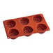 A red Silikomart silicone baking mold with rose-shaped compartments.