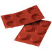 A red Silikomart silicone baking mold with six flan cavities.