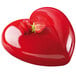 A red heart-shaped cake with a strawberry on top in a Silikomart AMORE baking mold.