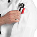 A person using a red pen to customize a white Uncommon Chef long sleeve chef coat.