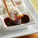 A sushi roll with Lee Kum Kee Unagi sauce on a white plate.