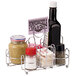 A Vollrath wire rack condiment caddy holding condiments and a bottle of sauce on a counter.