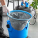 A person using a Lavex wet/dry vacuum to clean a blue bucket.
