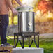 A man using a Backyard Pro brewing kit on a patio.