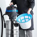 A man using a Lavex stainless steel wet/dry vacuum kit to clean a blue and white bucket.